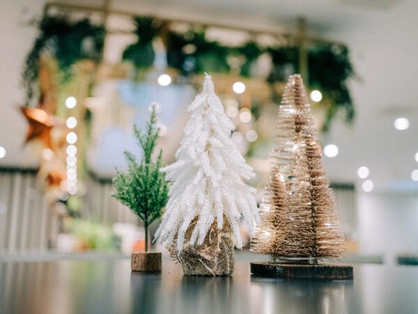 Klein creme wit kunstboompje op tafel met voet in jute.